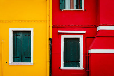 Facade of yellow and red colored houses with windows