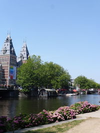 River by buildings against clear sky