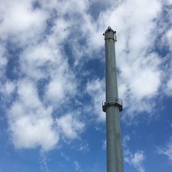 Low angle view of smoke stack against cloudy sky