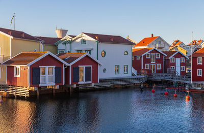 Buildings by river against sky