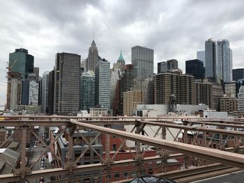 Modern buildings in city against cloudy sky