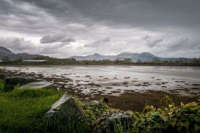 Scenic view of lake against cloudy sky