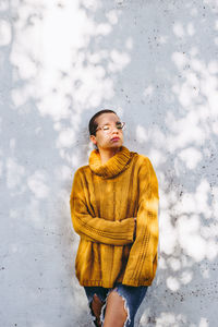 Woman looking away while standing in snow