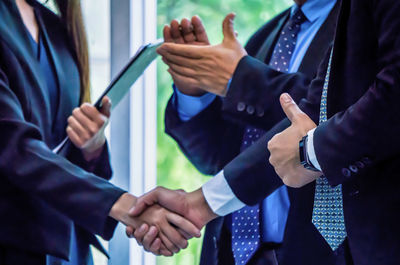 Midsection of entrepreneurs shaking hands