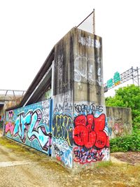 Graffiti on wall in city against clear sky