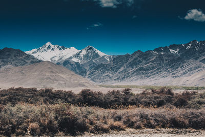 Scenic view of snowcapped mountains against blue sky