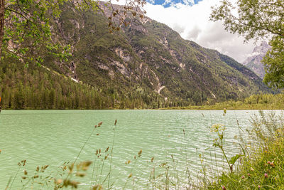 Scenic view of lake by mountains against sky