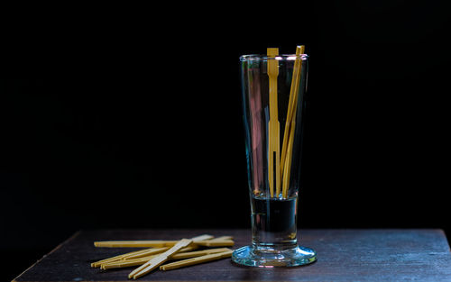 Close-up of wine glass on table against black background
