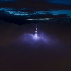 Illuminated tower against sky at night