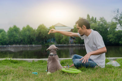 Man and dog sitting on field