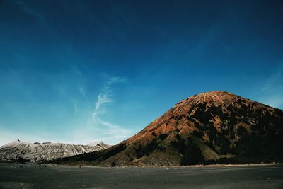 Scenic view of mountains against blue sky