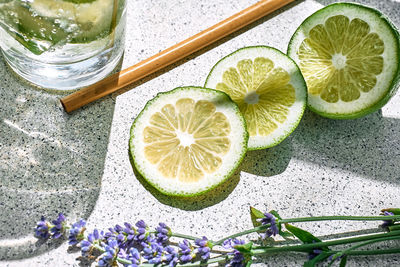 Lime slices and lavender flowers as ingrodients for cool lavender lemonade. top view.