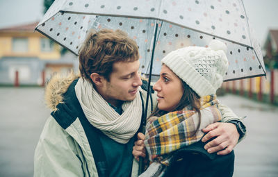 Young couple kissing in snow during winter