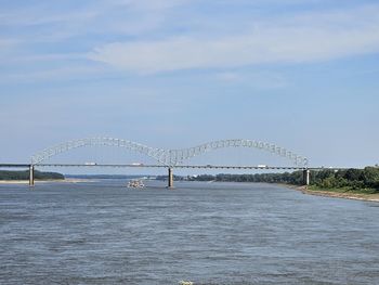 Bridge over river against cloudy sky