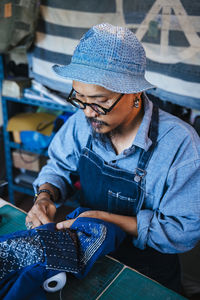 Man working over fabric on table