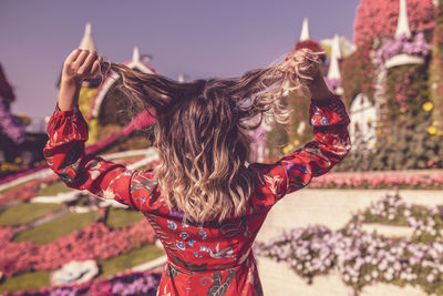 Rear view of woman with brown hair standing in public park