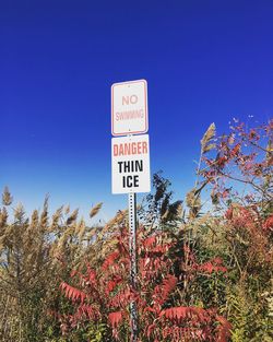 Low angle view of information sign against sky