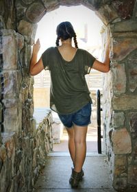 Rear view of teenage girl standing at entrance