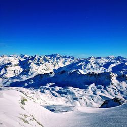 Scenic view of snowcapped mountains against clear blue sky