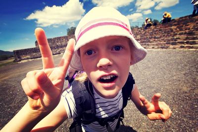 Close-up of girl making peace sign