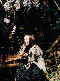 Side view of young woman sitting outdoors