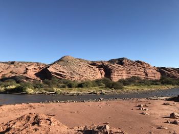 Scenic view of desert against clear blue sky