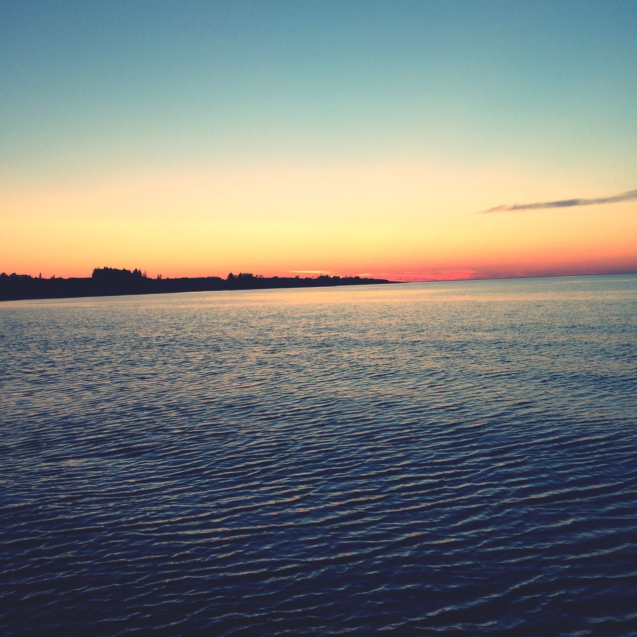 sunset, water, tranquil scene, scenics, copy space, clear sky, tranquility, waterfront, sea, beauty in nature, rippled, nature, sky, idyllic, dusk, orange color, blue, outdoors, silhouette, no people