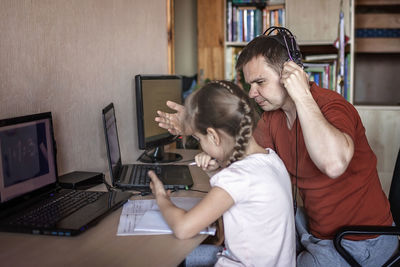 Father teaching daughter at home