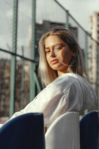 Portrait of young woman sitting outdoors