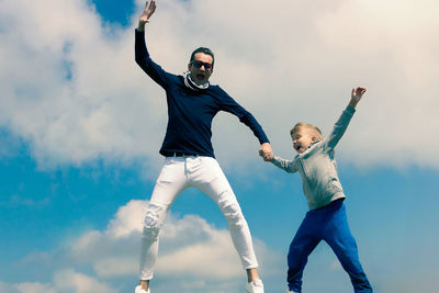 Full length of father with son against sky