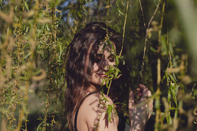 Side view of young woman amidst plants