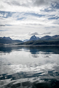 Scenic view of lake by snowcapped mountains against sky