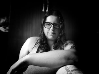 Portrait of young woman sitting on sofa at home