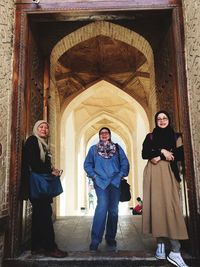 Full length of a woman standing against building