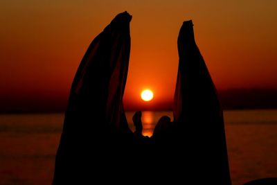 Close-up of silhouette person against orange sunset sky
