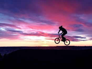 Silhouette of people riding bicycle