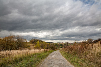 Road amidst field against sky