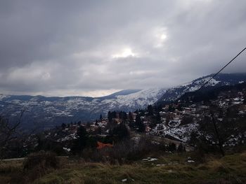 Aerial view of townscape and mountains against sky