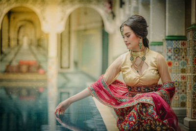 Woman looking away while sitting outdoors