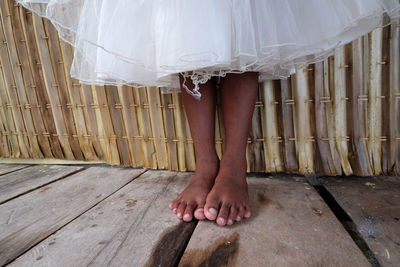 Low section of bride standing on wooden floor