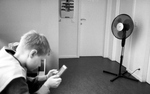 Side view portrait of boy sitting on mobile phone