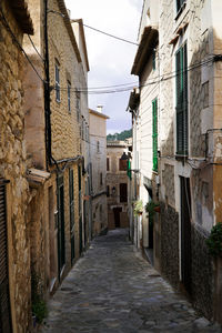 Clothes hanging amidst buildings against sky