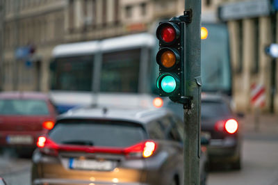 A city crossing with a semaphore on blurred background with cars in the evening streets, green light