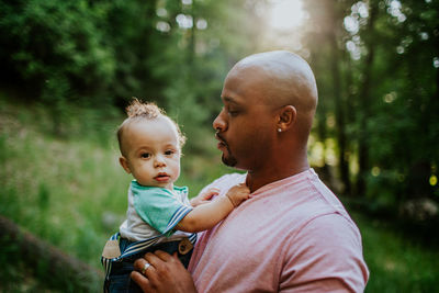 Father holding and looking at infant son