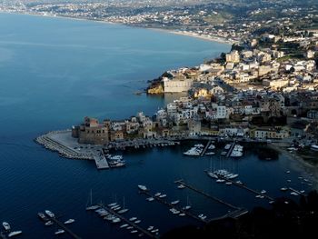 Aerial view of city by sea against sky