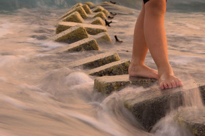 Person walking on stones in river