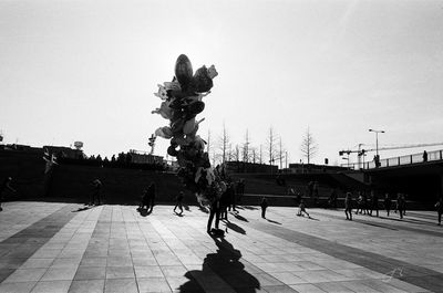 People walking on street against clear sky