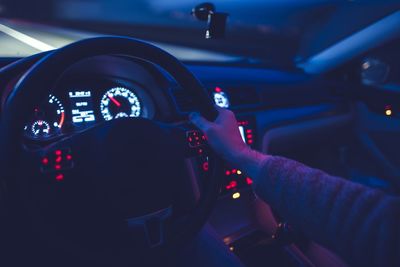 Close-up of man driving illuminated car