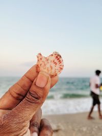 Close-up of hand holding hands on beach