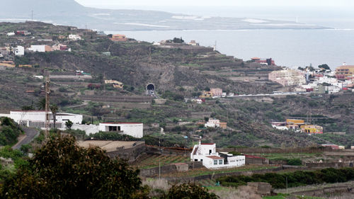 High angle view of town by sea against sky